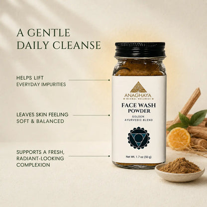 Anachaya Face Wash Powder in a glass bottle with a black cap and white label, shown on a warm beige background with marketing text and small ingredient props including cinnamon, orange slices, and a spoon of powder.