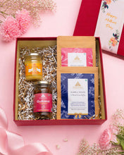 Load image into Gallery viewer, Open gift hamper showing A2 ghee jar, rose gulkand, kahwa tea, and spice tea neatly arranged with decorative fillers.