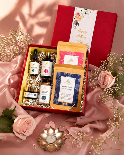 Open luxury hamper showing skincare products including body milk, rose water, face masque, face wash powder, and herbal teas arranged neatly.