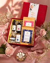 Load image into Gallery viewer, Open luxury hamper showing skincare products including body milk, rose water, face masque, face wash powder, and herbal teas arranged neatly.